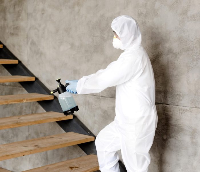 side-view-man-disinfecting-stairs-1-scaled